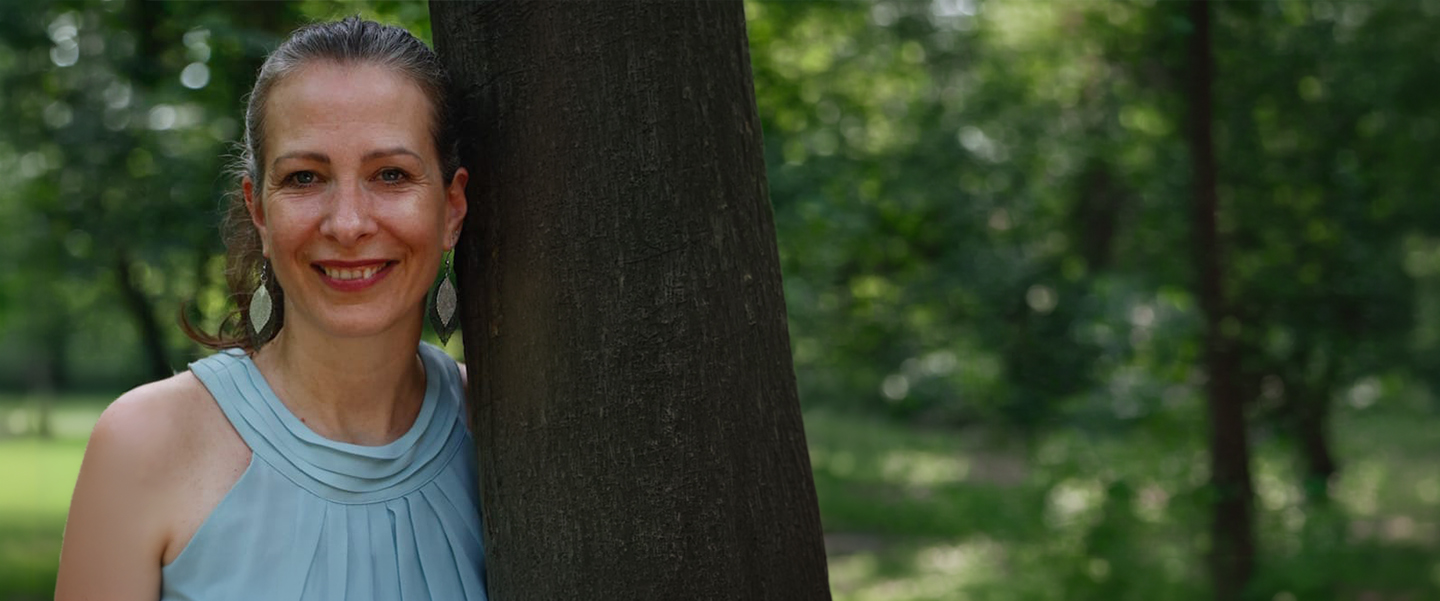 Evelyn Wiese lehnt am Baum.