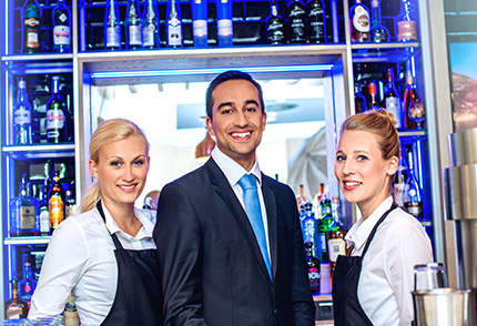 Gastronom mit zwei Kolleginnen an der Theke