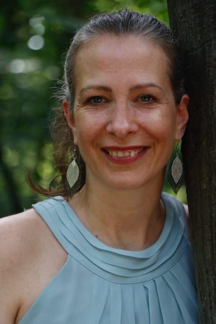 Evelyn Wiese lehnt am Baum.